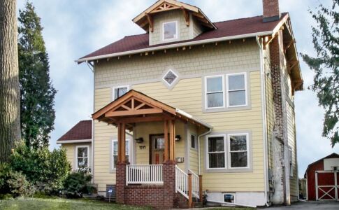 Craftsman detailing and shingle siding enhance the curb appeal of this suburban home. Craftsman-inspired exterior