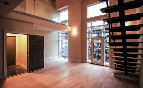 The top units receive the benefit of double-height space in the living room, with tall expanses of window to bring in natural light. Two-story living space