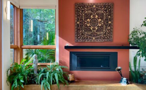Materials, forms, and matching indoor/outdoor planters blur the distinction between interior and exterior space. A simple palette of earth-tone materials with crisp, clean detailing evokes a feeling of serenity throughout. Photo of fireplace and indoor planters
