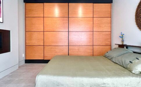 Shoji-style sliding bamboo closet doors help foster a Zen-like calm in the master bedroom -- while efficiently hiding away generous amounts of storage. Photo of bamboo closets