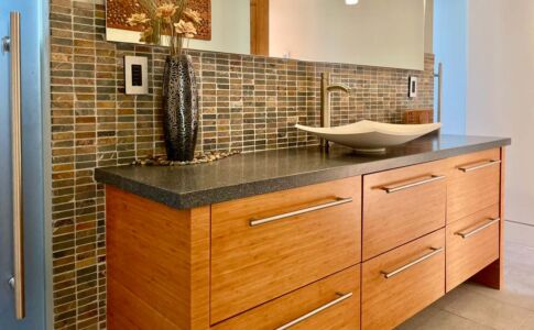 Bamboo cabinets and slate ledger tile recall materials found elsewhere throughout the home, creating a sense of continuity and harmony. The master bath is compartmentalized to allow maximum flexibility of use for all members of the family. Photo of custom bath vanity