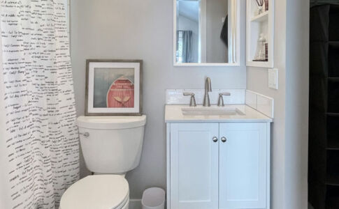 The ADU's compact bathroom receives natural daylighting from a high window in the shower. New bathroom at garage conversion ADU