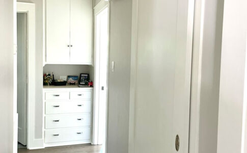 Stacked full-size washer and dryer are hidden away behind the sliding barn door. Photo of barn door laundry closet - closed