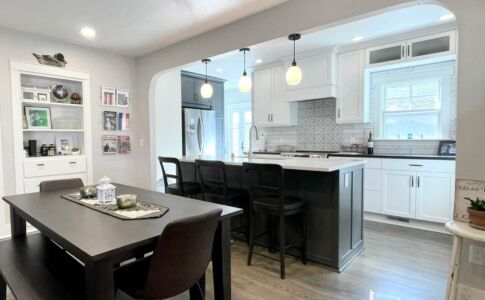 The insertion of a structural beam allowed removal of the wall that had fully separated the galley kitchen from the dining room. The new opening's curved arch recalls the form of the original passageway between living room and dining room, in keeping with the character of this early 1940's house. Photo of remodeled kitchen & dining room