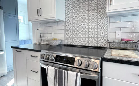 Modern high-efficiency induction cooking is paired with cabinets and finishes which recall an earlier time. Photo of remodeled kitchen