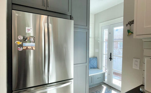 Just beyond the kitchen, a new entry vestibule addition leads out to the side yard and bathes the kitchen in natural light. Photo of remodeled kitchen