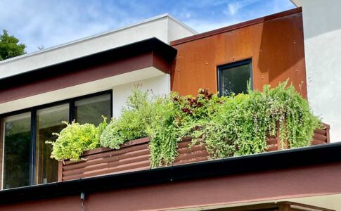 The entry features a small roof garden with planter, as a means to incorporate the landscaping into the structure itself. Photo of rooftop planter