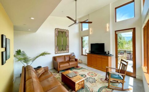Upstairs, a light-filled family room leads onto the carport roof deck, with views over the city. A built-in AV cabinet hides away all the technology associated with the TV. Photo of light-filled room with TV